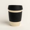 Beige reusable coffee cup with black band and lid. Band embossed with the AA logo