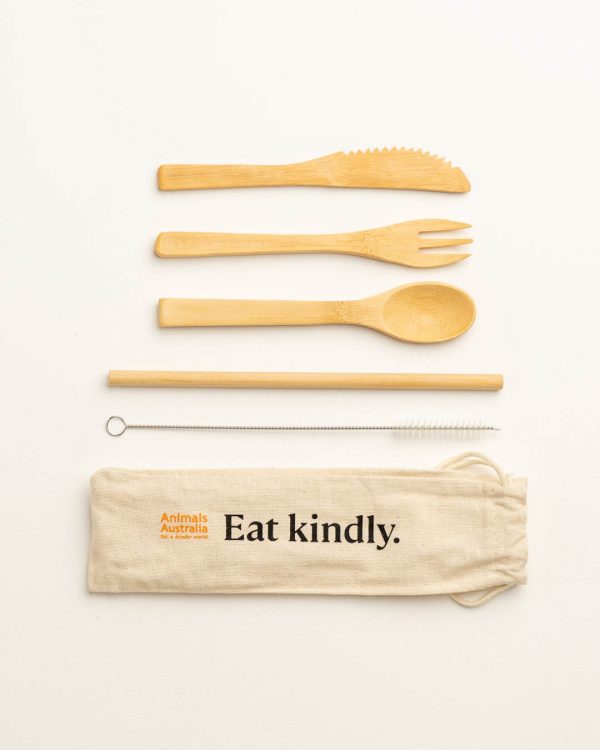 Bamboo fork, spoon, knife, straw and metal straw cleaner. With beige carry bag that has the AA logo in orange and the words 'Eat kindly.'