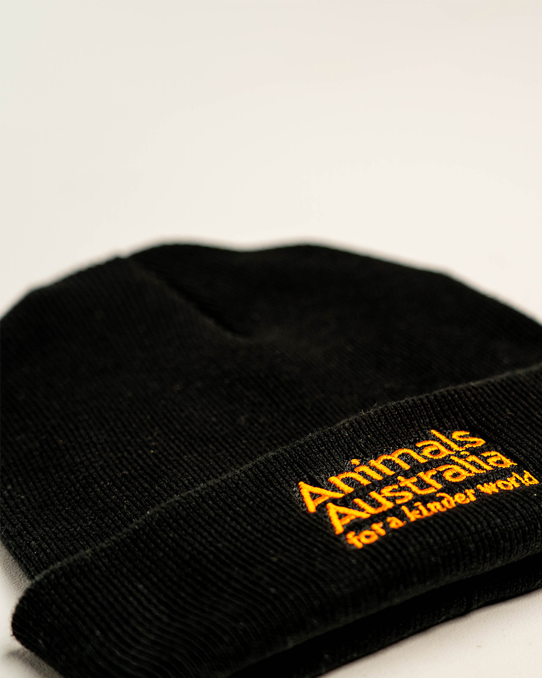 Front of black beanie with the AA logo embroidered in orange