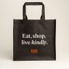 Black shopper bag with orange Animals Australia logo and a quote - "Eat, shop, live kindly"