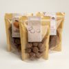 Pack of choc coated macadamias in front of a pack of salted caramels and turkish delight