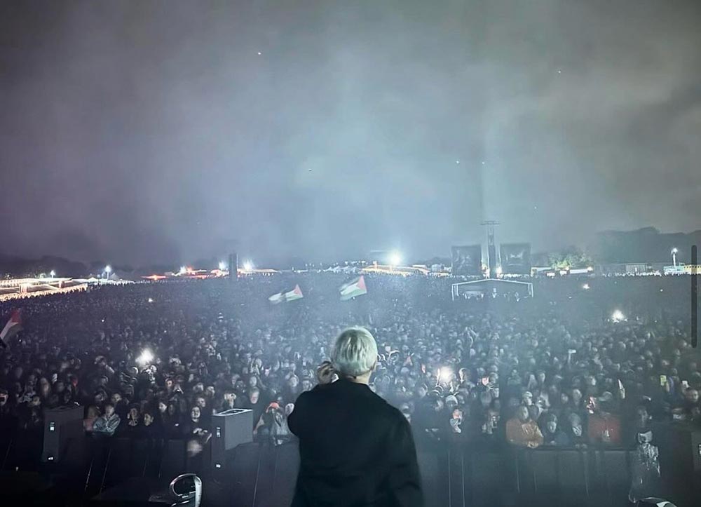 A view from the stage at the music festival looking out onto the crowd. It is night.