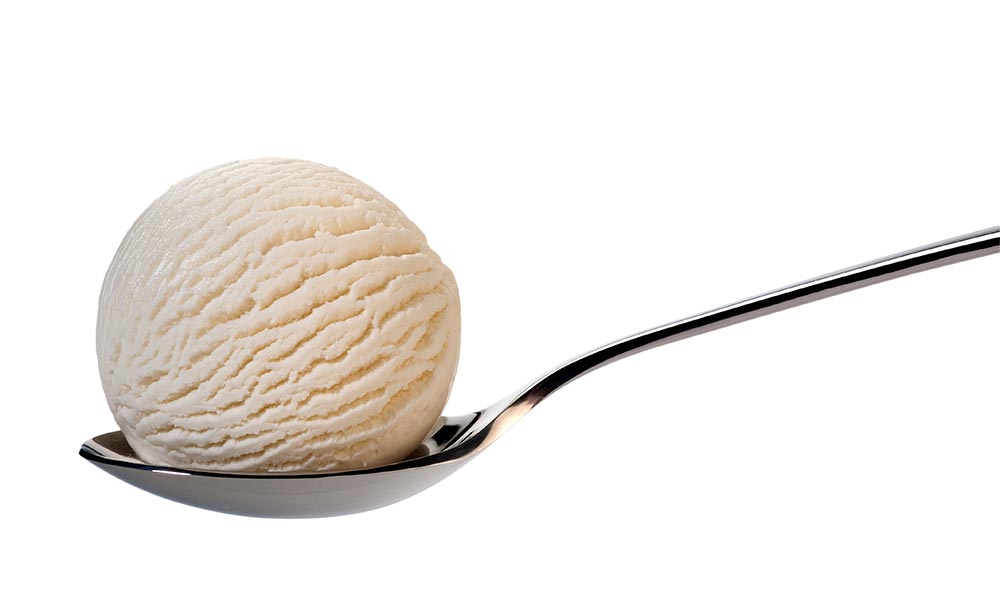 A scoop of vanilla ice cream on a dessert spoon.