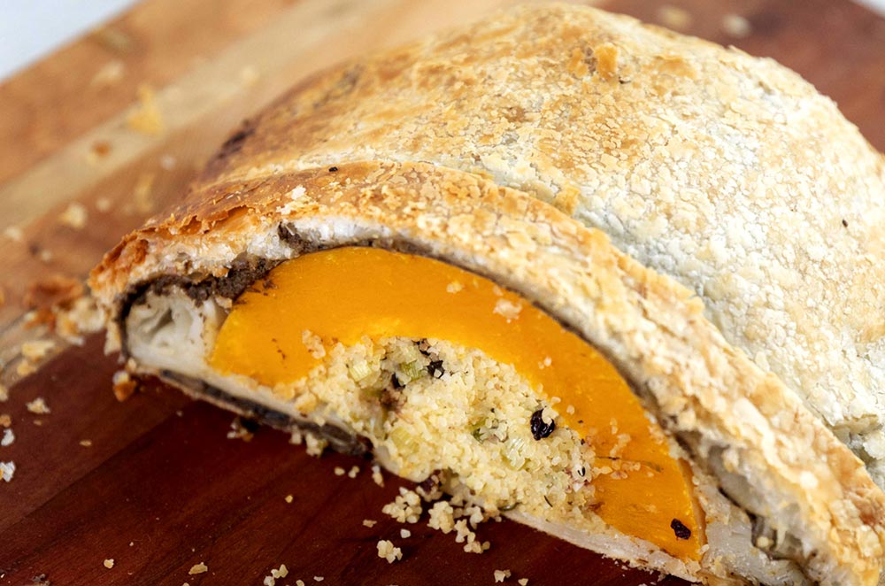 A pastry-covered pumpkin wellington, cut to reveal a flavourfully-stuffed centre,