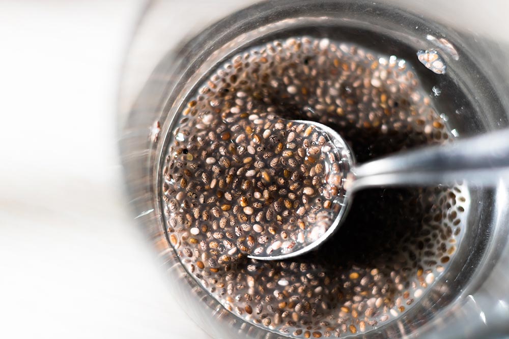 Overhead view of chia seeds and water in a jar, making 'chia egg'.