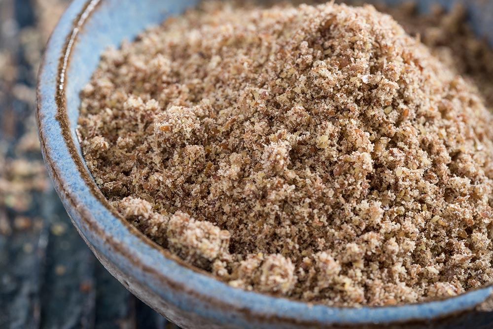 Flaxseed meal in a blue bowl.