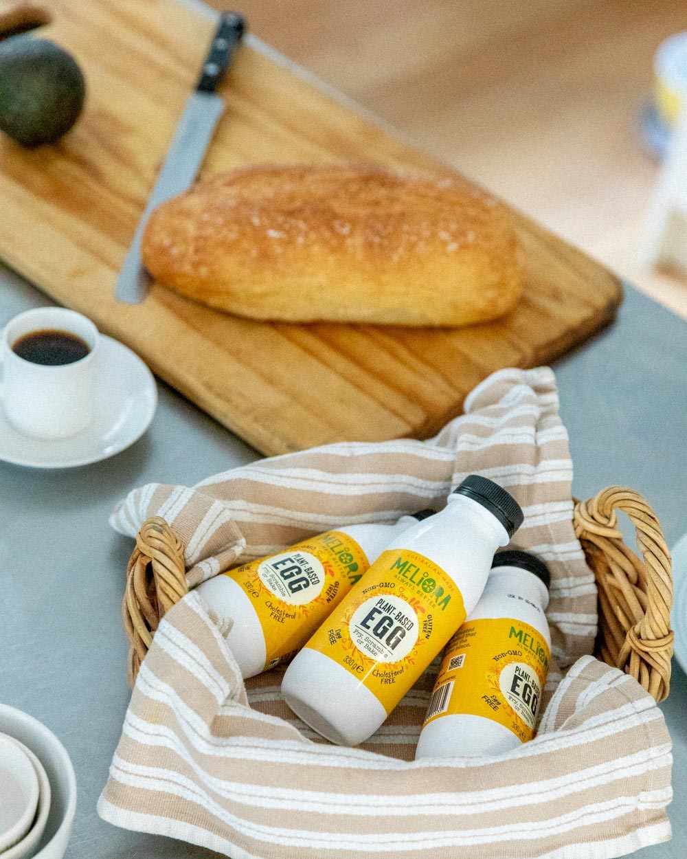 A basket with bottles of Meliora liquid egg are placed on a bench.