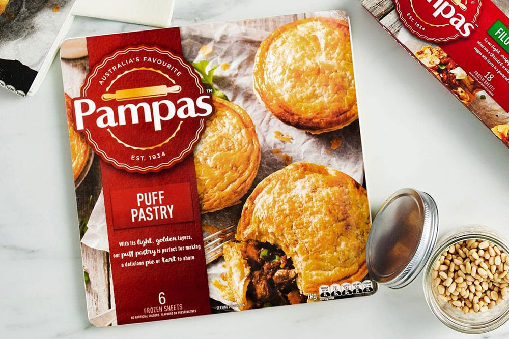 Overhead shot of a packet of Pampas Puff Pastry on a white bench.