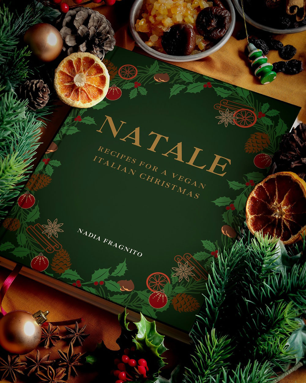 A copy of the book 'Natale' is set on a table surrounded by Christmas decorations.